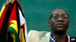 FILE - Zimbabwean Pastor Evan Mawarire holds his country's flag before addressing supporters at the University of the Witwatersrand in Johannesburg, South Africa, July 28, 2016.