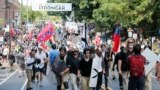 White nationalist demonstrators walk through town after their rally was declared illegal near Lee Park in Charlottesville, Va., Aug. 12, 2017. 