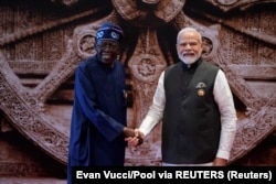 Perdana Menteri India Narendra Modi berjabat tangan dengan Presiden Nigeria Bola Ahmed Tinubu saat tiba di pusat konvensi Bharat Mandapam untuk menghadiri KTT G20 di New Delhi, India, Sabtu, 9 September 2023. (Foto: Evan Vucci/Pool via REUTERS)