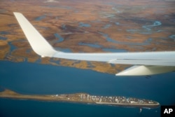 Air Force One, carrying President Barack Obama, flies over the island village of Kivalina, an Alaska Native community of 400 people already receding into the ocean as a result of rising sea levels, on its way to Ralph Wien Memorial Airport in Kotzebue, Al