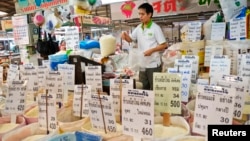 A Thai vendor weighs a bag of rice at a market in central Bangkok, July 26, 2013.