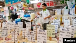 FILE - A Thai vendor weighs a bag of rice at a market in central Bangkok, July 26, 2013. Thailand's military-led cabinet could formally agree as soon as next week to pursue Trans-Pacific Partnership (TPP) membership.