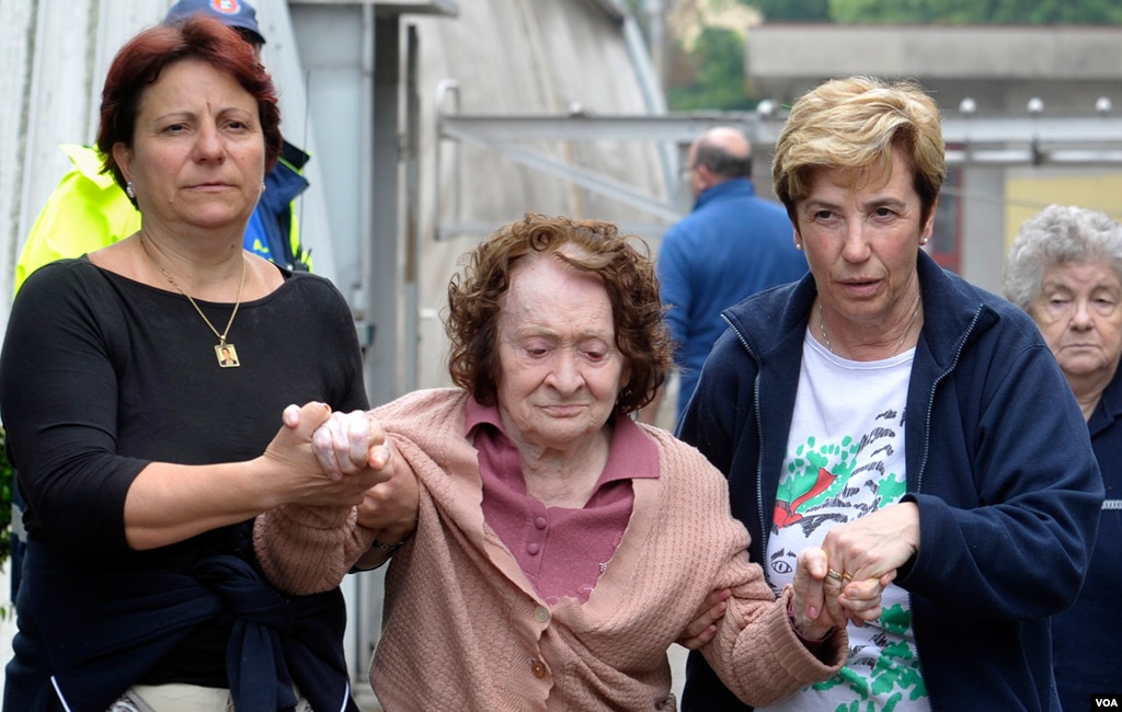 An elderly woman who had to leave her home is assisted in Finale Emilia northern Italy, May 20. 2012. (AP Photo/Marco Vasini)