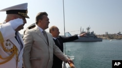 Ukrainian President Viktor Yanukovych, second left, inspects navy ships with Russian President Vladimir Putin in the Ukrainian Black Sea port of Sevastopol in the Crimea, July 28, 2013.