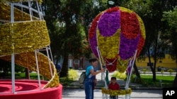 Una mujer se toma una selfie con su hija dentro de una decoración navideña en Caracas, Venezuela, el martes 1 de octubre de 2024.