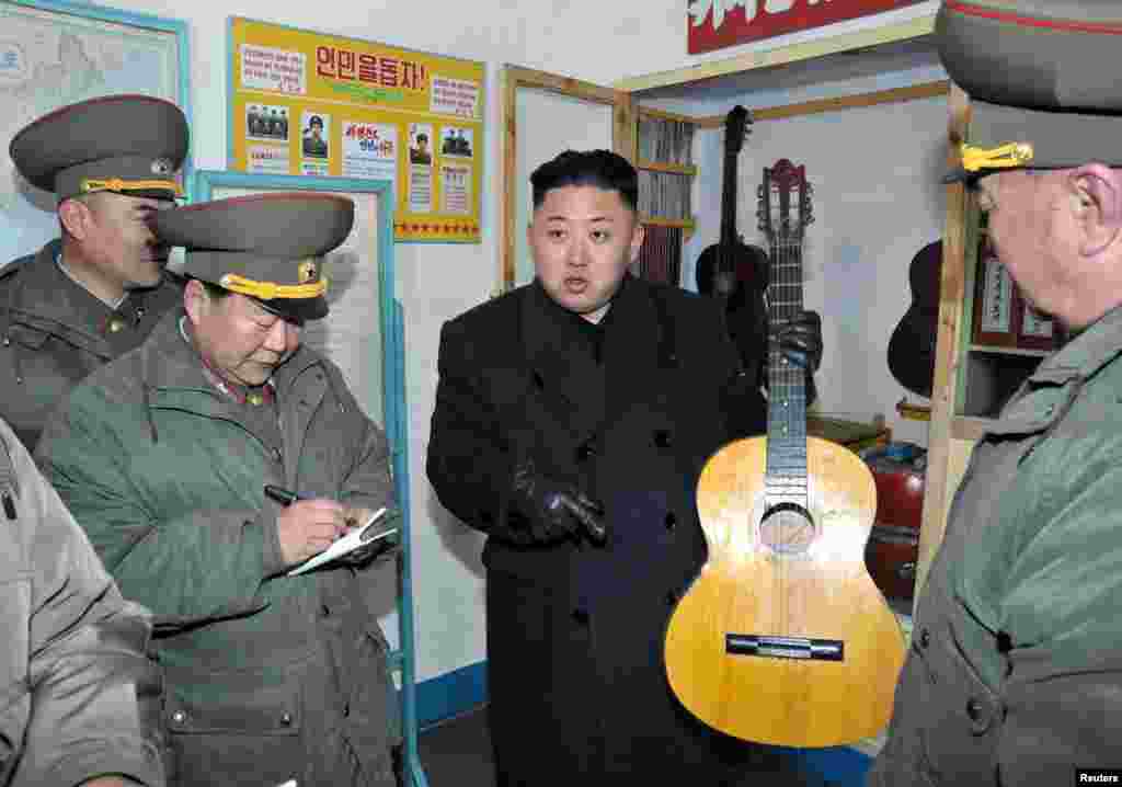 North Korean leader Kim Jong Un holds a guitar during his visit to a military unit on the Wolnae Islet Defence Detachment in the western sector of the front line, which is near Baengnyeong Island, South Korea, March 11, 2013. (KCNA)