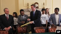 From left to right: Brazilian Vice President Michel Temer, former Brazilian football star Pele, British Prime Minister David Cameron and Ethiopian running legend Haile Gebreselassie gather for a 'Race Against Hunger' photo call at 10 Downing in London Sun