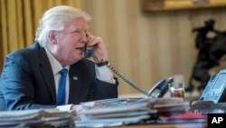 FILE - President Donald Trump speaks on the phone with Russian President Vladimir Putin, Jan. 28, 2017, in the Oval Office at the White House in Washington. 
