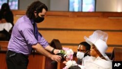 A mourner offers Tomika Miller, the wife of Rayshard Brooks, some flowers while attending his public viewing at Ebenezer Baptist Church on June 22, 2020, in Atlanta.