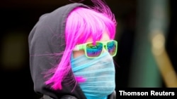 FILE - A person wears a scarf as a protective face mask in Melbourne after it became the first city in Australia to enforce mask-wearing in public as part of efforts to curb a resurgence of COVID-19, July 23, 2020. 