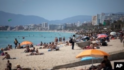 Tourists enjoy the beach at the Spanish Balearic Island of Mallorca, Spain June 7, 2021, as Spain is jumpstarting its summer tourism season by welcoming vaccinated visitors from most countries who can prove they are not infected with coronavirus. 