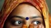 FILE - A woman wearing a bindi waits after casting her vote at a polling station in the old quarters of Delhi.