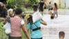 Cambodia family members wade though flood waters in Croy Changvar village in Phnom Penh, Cambodia, Wednesday, Sept. 28, 2011. 