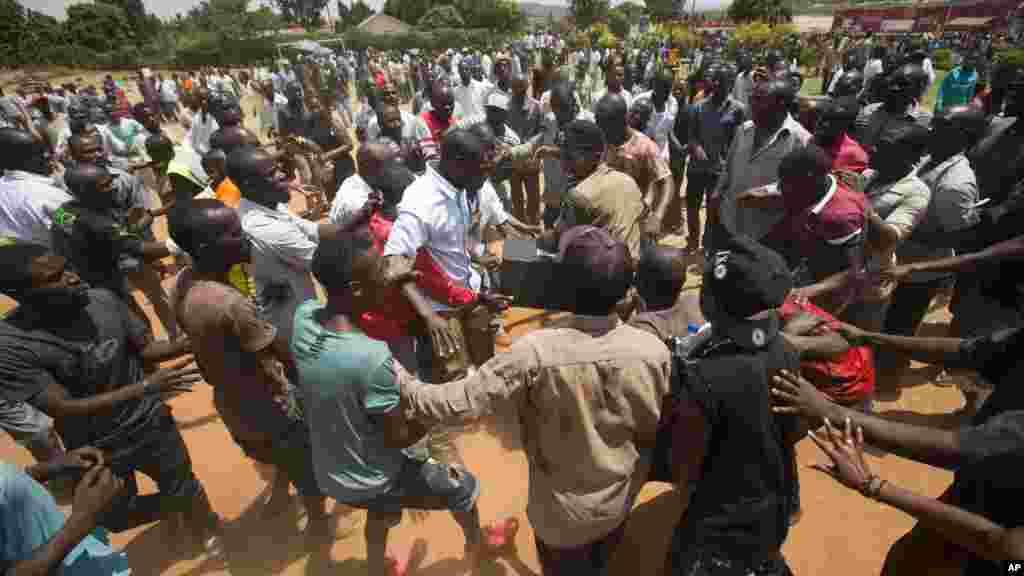 Confrontation entre les Ougandais et les policiers après avoir attendu plus de 7 heures sans être en mesure de voter dans un bureau de vote dans Ggaba, les forces de l&#39;ordre ont mal à garder la main sur une boîte contenant les matériel électoraux,en Ouganda jeudi 18 février