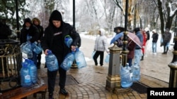 Кияни набирають воду після ударів Росії по цивільній інфраструктурі України, 24 листопада 2022. REUTERS/Valentyn Ogirenko