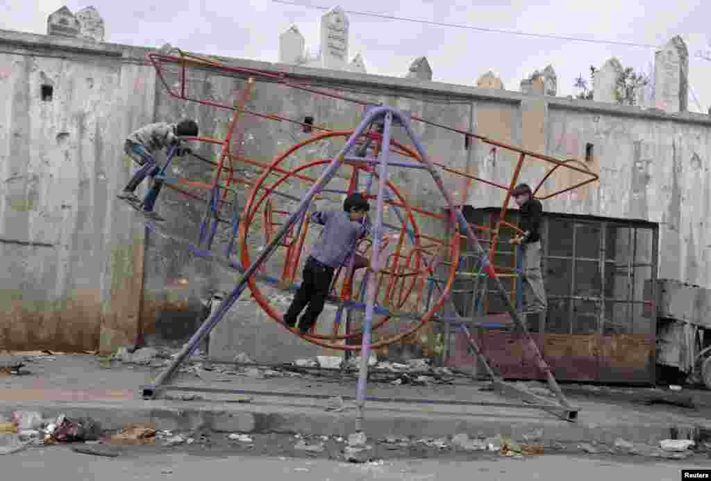 Children play on swings in Aleppo, Syria, October 23, 2012. 