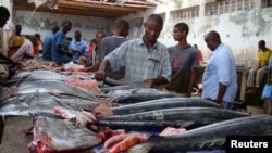 FILE - Somali traders prepare sword fish at the Hamarweyne market in southern Mogadishu, Aug. 16, 2010. 