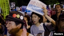 Members of Students Emergency Action for Liberal Democracy shout slogans during a protest outside parliament in Tokyo, Aug. 21, 2015.