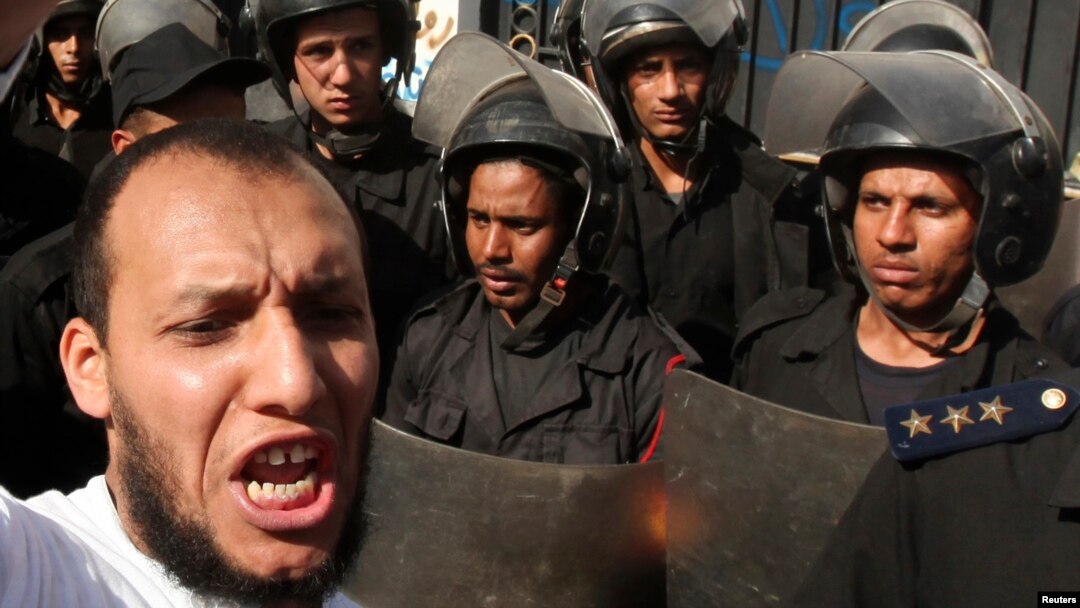 Police stand guard near an Islamist protester outside the Iranian ambassador's house during a protest against Iran in Cairo. (File photo).