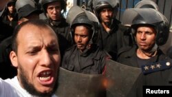 Police stand guard near an Islamist protester outside the Iranian ambassador's house during a protest against Iran in Cairo. (File photo).