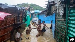 Anak-anak pengungsi Rohingya bermain di air banjir di kamp pengungsi Rohingya di Kutupalong, Bangladesh, Rabu, 28 Juli 2021.