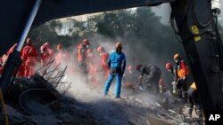 Members of rescue services search for survivors in the debris of a collapsed building in Izmir, Turkey, Nov. 2, 2020.