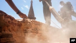 Using brooms and bare hands, soldiers and residents clean up earthquake-damaged Htilominlo Pagoda in Bagan, Myanmar, Aug. 25, 2016.