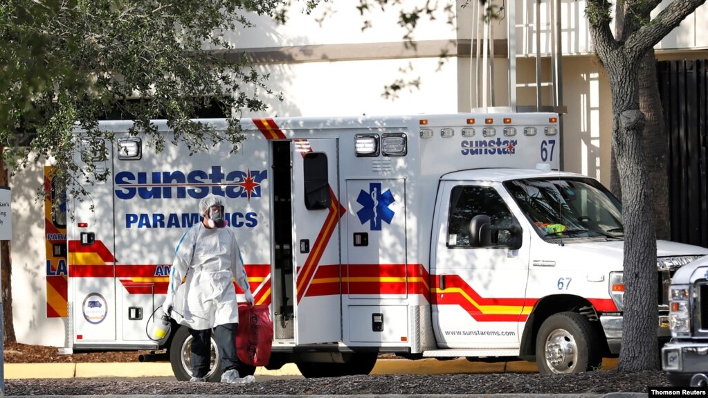 A paramedic dressed in personal protective equipment exits an ambulance at St. Petersburg General Hospital in Florida