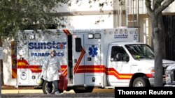 A paramedic dressed in personal protective equipment exits an ambulance at St. Petersburg General Hospital in Florida