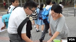 有中學生經過陳澤滔擺設的街站，簽名支持興建寵物公園。(美國之音湯惠芸拍攝)