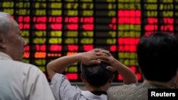 Investors look at an electronic board showing stock information at a brokerage house in Shanghai, China, June 20, 2018. 