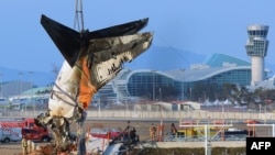 A crane lifts the tail section during the salvage operation of the Jeju Air Boeing 737-800 aircraft which crashed and burst into flames at Muan International Airport, in Muan on January 3, 2025.