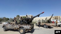 FILE - Forces loyal to Libya's Government of National Accord celebrate, April 18, 2019, after taking control of al-Aziziyah, located some 40 kilometers south of the capital Tripoli, following fierce clashes with forces loyal to strongman Khalifa Haftar.