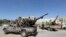 FILE - Forces loyal to Libya's Government of National Accord celebrate, April 18, 2019, after taking control of al-Aziziyah, located some 40 kilometers south of the capital Tripoli, following fierce clashes with forces loyal to strongman Khalifa Haftar.