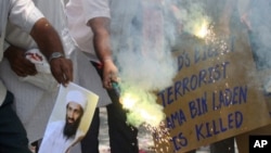 People burn a photograph of al-Qaida leader Osama bin Laden as they celebrate his death in the western Indian city of Ahmedabad, May 2, 2011.