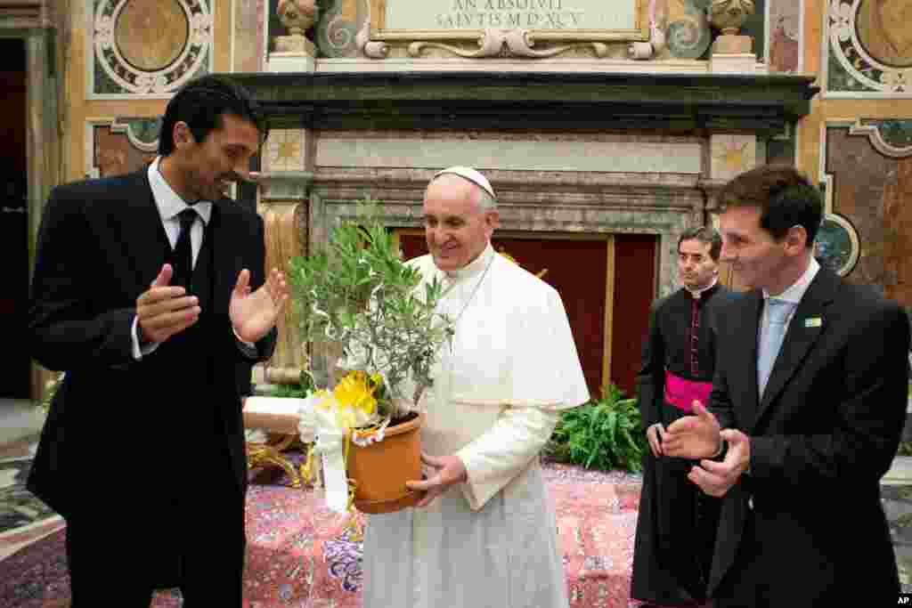 Le pape François est applaudi par le gardien italien Gianluigi Buffon, à gauche, et la star du football argentin Lionel Messi lors d'une audience privée au Vatican, 13 août 2013. (Le journal du Vatican L'Osservatore Romano)