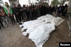 Para pelayat berdoa di samping mayat termasuk empat warga Palestina yang tewas dalam serangan Israel terhadap mobil, di Rafah di Jalur Gaza selatan, 21 Januari 2024. (Foto: REUTERS)