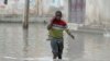 A boy makes his way through flood water caused by heavy rain, in Mogadishu, Somalia, Saturday, Nov. 11, 2023 