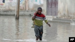 A boy makes his way through flood water caused by heavy rain, in Mogadishu, Somalia, Saturday, Nov. 11, 2023 