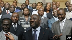 Incumbent President Laurent Gbagbo, center, gestures during a photo opportunity with his newly-named cabinet, with Prime Minister N'Gbo Gilbert Marie Ake, front left, at the presidency in Abidjan, Ivory Coast, Dec 7, 2010