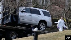 FILE - Investigators load an SUV onto a truck in Staten Island, New York, March 14, 2019. Francesco "Franky Boy" Cali was found with multiple gunshot wounds at his red-brick colonial-style house on Staten Island on Wednesday night and was pronounced dead at a hospital.