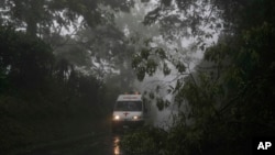 ARCHIVO - Una ambulancia de la Cruz Roja sale de una zona afectada por la lluvia en Comasagua, El Salvador, el lunes 10 de octubre de 2022.