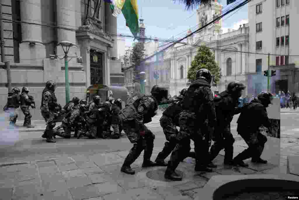 Riot police take their positions during a protest of health care workers against new government measures to fight the coronavirus pandemic, in La Paz, Bolivia.
