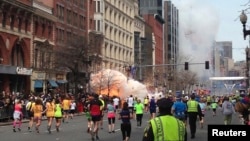 Para peserta marathon Boston terus menyelesaikan lomba larinya menuju garis finish di saat sebuah bom meledak di dekatnya, Senin 15 April 2013. (Foto: Reuters/Dan Lampariello).