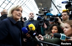 FILE - Marine Le Pen, candidate for the far-right French National Front, talks to journalists in Villepinte, France, Dec. 2, 2016.