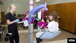 Seorang siswa sekolah perawat di University of Missouri berlatih menggunakan perangkat untuk membantu perawat memindahkan pasien.