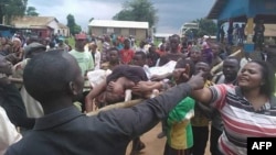 Une dispute entre manifestants qui transportent sur civière une victime devant l'hôpital local à Beni, Nord-Kivu, 15 août 2016. 
