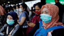 Para penumpang mengenakan masker saat menunggu kereta di sebuah stasiun di Jakarta, 2 Maret 2020.