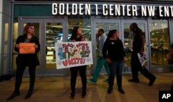 FILE - Demonstrators protesting the shooting death of Stephon Clark by Sacramento Police officers March 18 block the entrance to the Golden 1 Center, preventing ticket holders from entering to watch the Dallas Mavericks play the Sacramento Kings in an NBA basketball game in Sacramento, California, March 27, 2018. The Sacramento Kings released a statement saying refunds would be given for those ticket holders who were not able to get in.