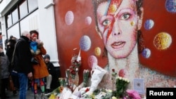 Une femme maquillee au style Ziggy Stardust pleure devant une peinture murale de David Bowie à Brixton, au sud de Londres, 11 janvier 2016.